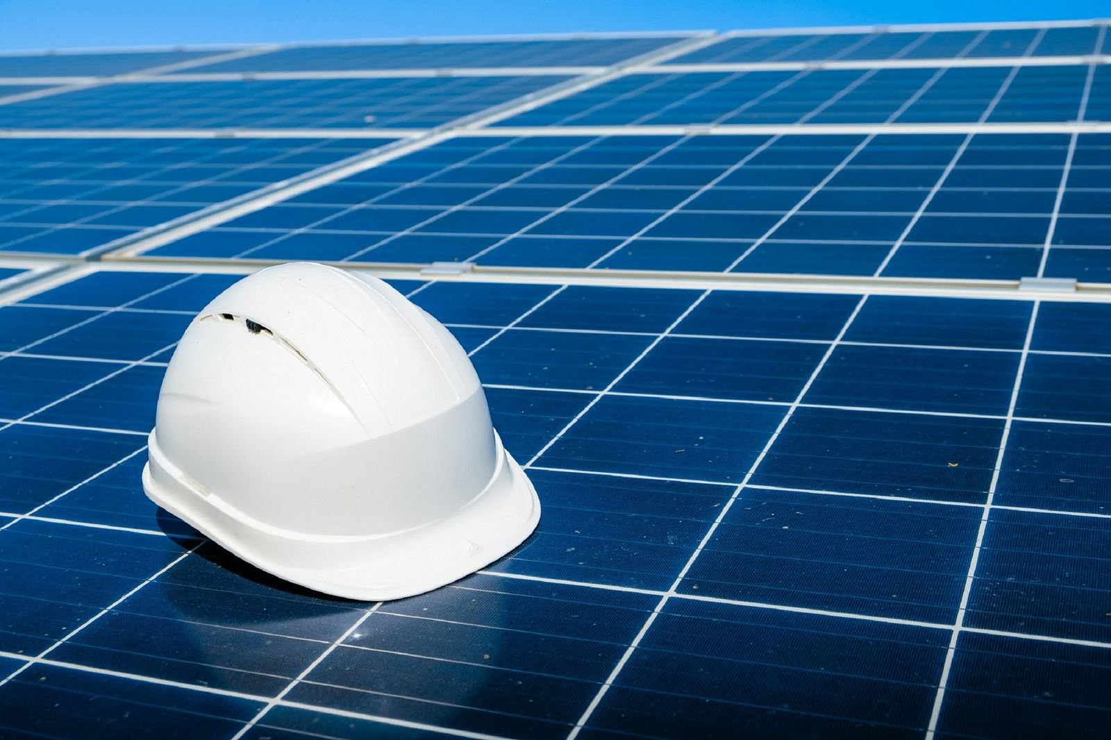 Weißer Schutzhelm auf einem Solarmodul