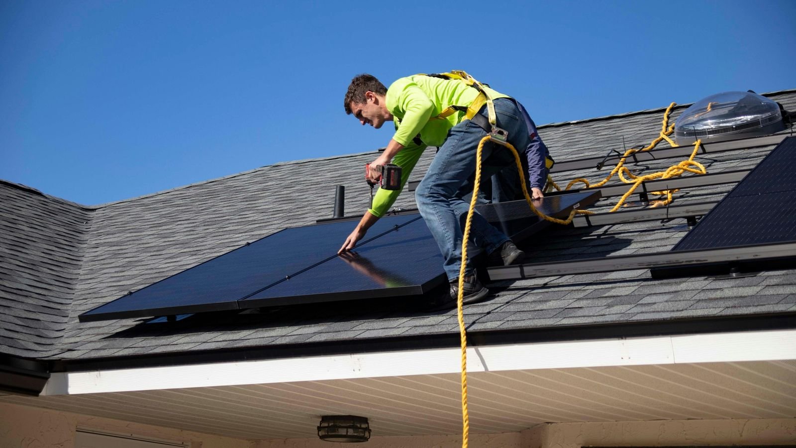Monteur befestigt ein Solarmodul auf einem Dach