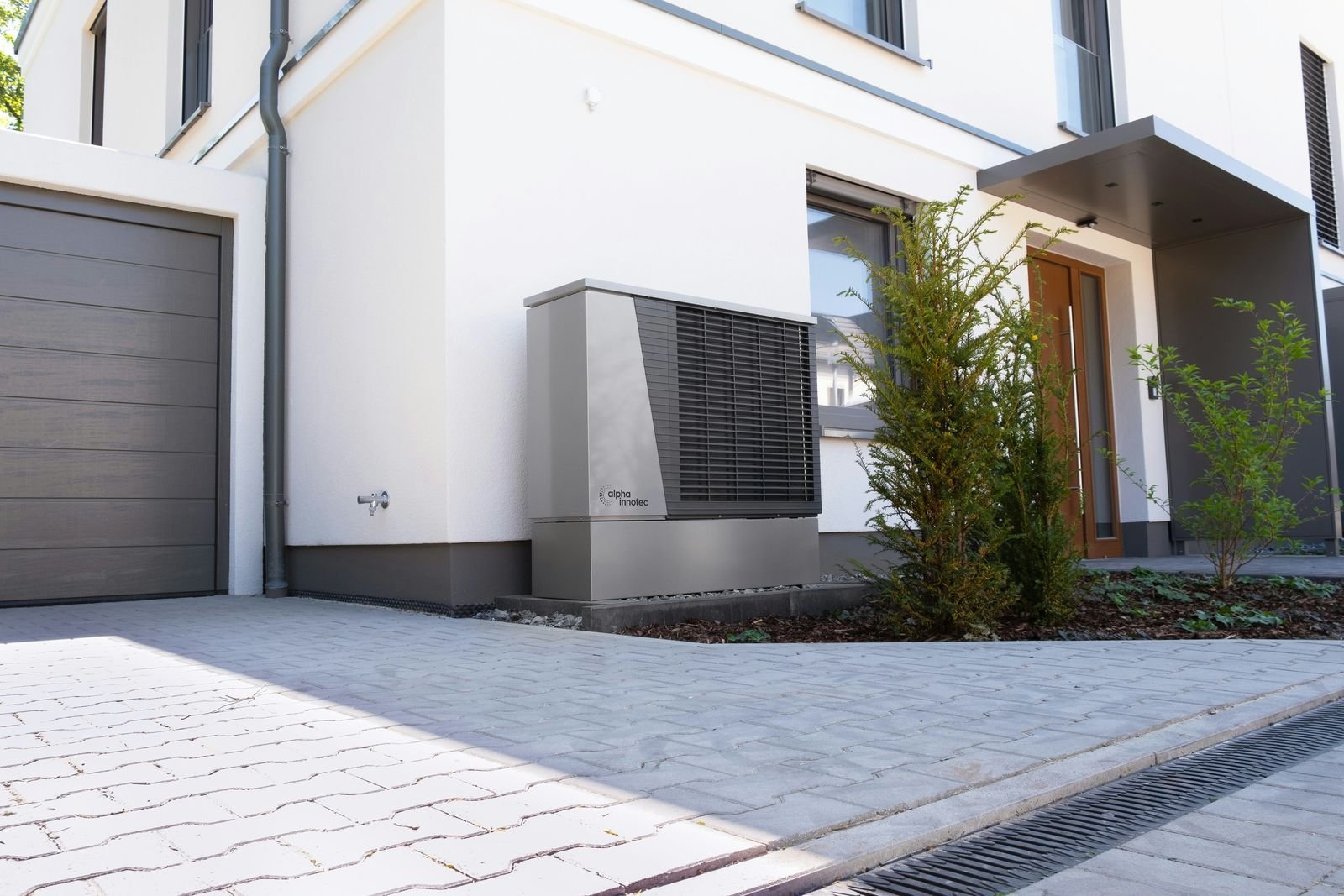 Luft-Wasser-Wärmepumpe an der Fassade eines modernen Wohnhauses
