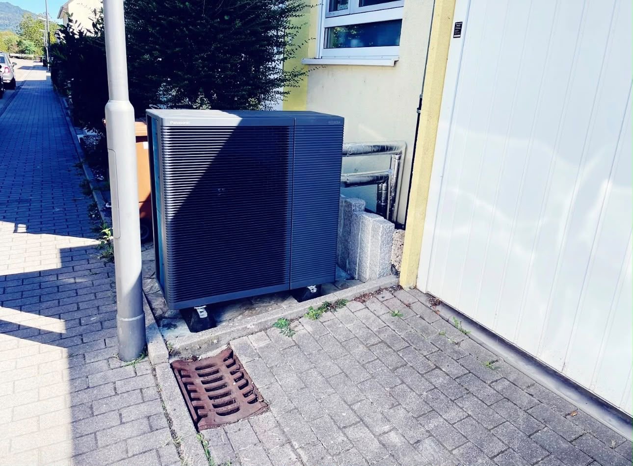 Wärmepumpen-Außeneinheit neben einer Garage